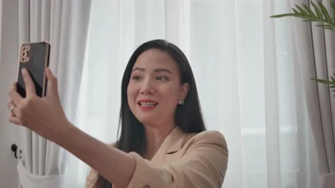 Close-up video of a woman using a mobile phone to video call with a colleague. Video stock 198112469