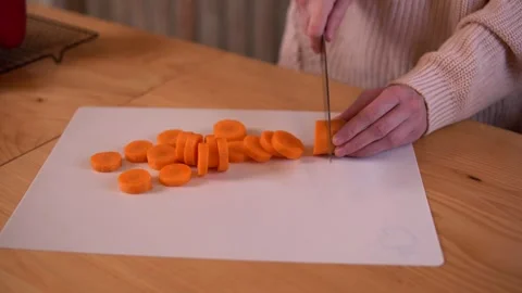 Close-up video of woman’s hands chopping a carrot on a white chopping board. Stock-Footage 308768158