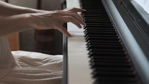 Close-up video of woman's hands playing the piano in pink dress Stock Footage 282976268