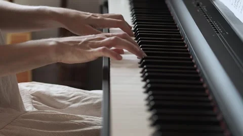 Close-up video of woman's hands playing the piano in pink dress Stock Footage 282976474