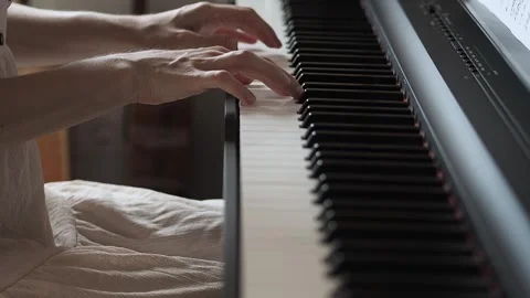 Close-up video of woman's hands playing the piano in pink dress Stock Footage 285406375