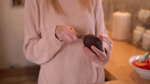 Close-up video of woman’s hands scooping an avocado during food preparation. Video stock 266455212