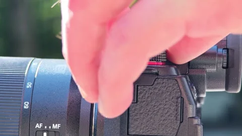 Close up of a videographers hands adjusting focus and other settings on a Vidéo 312122666