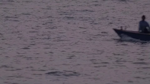 Close up view of 2 persons in a boat riding across in the ocean Stock Footage 72454745