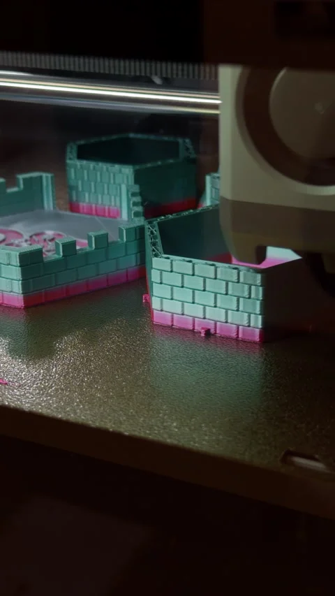 Close view of 3D printer nozzle building small architectural model with colorful Vídeos de archivo 345765656