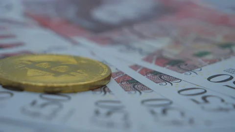 A close up view of £50 notes and a bitcoin coin. Stock Footage 165515677