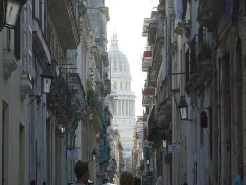 Close-up view above central main bright street lit with sunset onto old colonial Stock Footage 69793248
