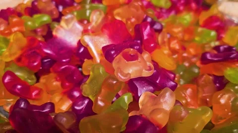Close view across a pile of gummy bears in a candy shop, showing orange, red Stock Footage 341402717
