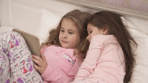 Close up view of adorable children lying in bed and using the tablet Stock Footage 104277342