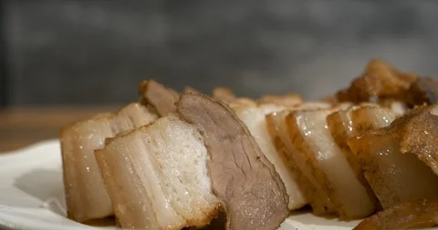 Close up view of a adult hand using chopsticks to pick up a slice of roasted  Stock Footage 94453403