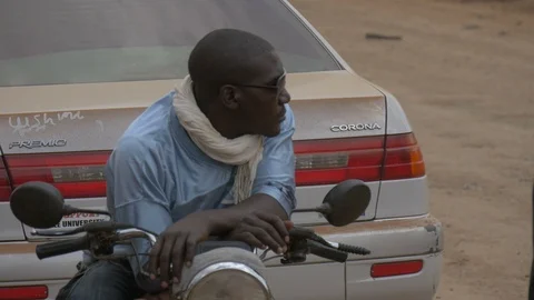 Close up view of an African man sitting on a motorbike Stock Footage 87076977