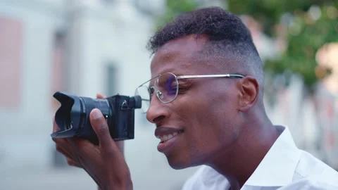 Close up view of a afro photographer taking a photo outdoors Vídeo Stock 202239734