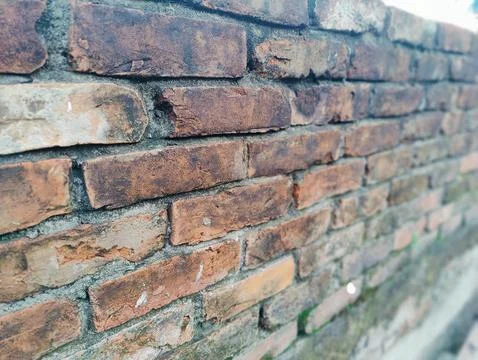 A close-up view of an aged brick wall showing weathered texture, mortar joi.. Stock Photos