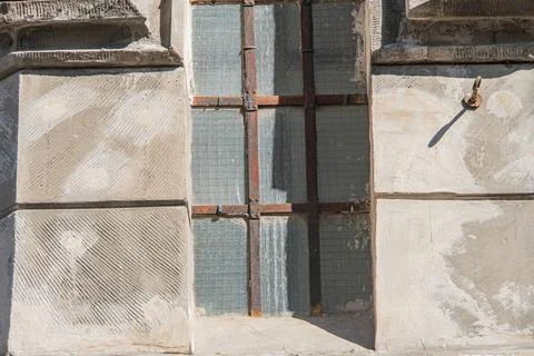 Close-up view of an aged Gothic church window in ruins, with bars and missi.. Stock Photos
