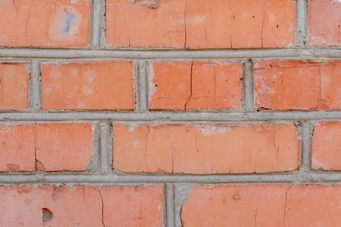 Close-up view of aged red brick wall showing cracks and mortar Stock Photos