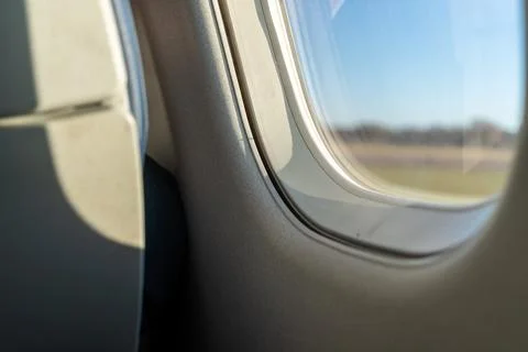 Close view of airplane window frame and seat interior with soft light Photos