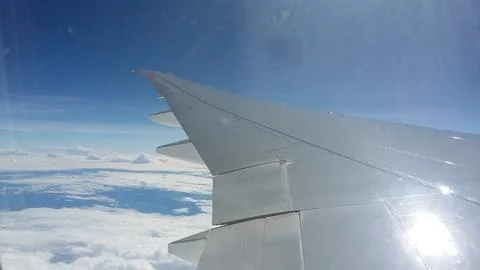 Close-up view of an airplane wing from a passenger window during flight above a  Stock Photos