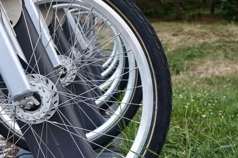 Close-up view of aligned bicycle wheels in a row at a bike sharing station. Foto stock