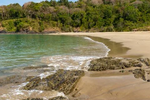 A close up view along a beach surrounded by lush forest on the island of Koh Stock Photos