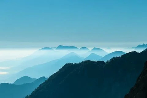 A close up view on the Alpine chains shrouded in the morning fog, seen from.. Stock Photos