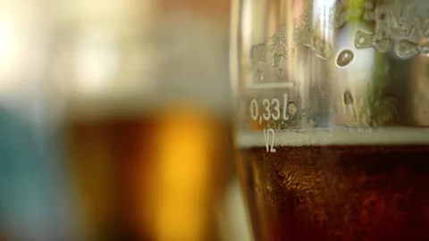 Close-up view of amber beer in a chilled glass with condensation and foam Stock Footage 342420861