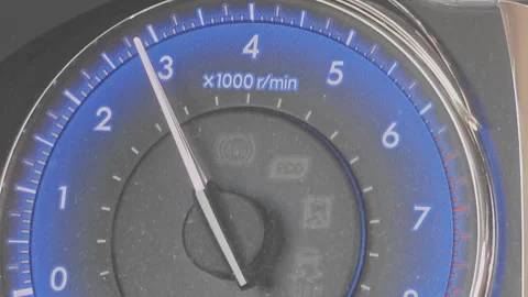 Close up view of an analog car tachometer. The needle moves up the dial Stock Footage 345600708
