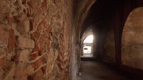 Close view of ancient stone corridor wall with arch passage and light exit Stock Footage 334629343
