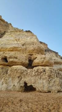 Close-up view of ancient weathered limestone cliffs featuring natural caves,  Photos