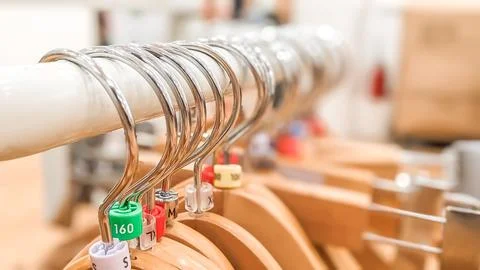 Close-up view and selective focus. Empty wooden hangers with Plastic size tags Stock Photos