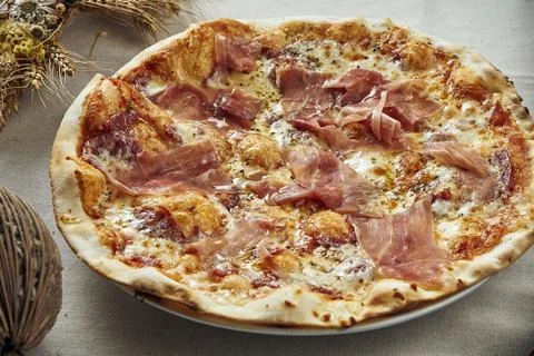 Close up view on Appetizing with melted cheese, prosciutto and salami on a li Stock Photos