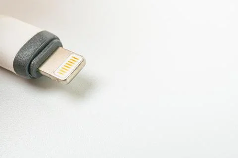 Close-up view of an Apple Lightning cable on a white background, showcasing.. Stock Photos