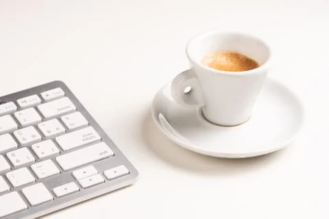 A close up view of arranged computer keyboard,cup of coffee on white table Stock Photos