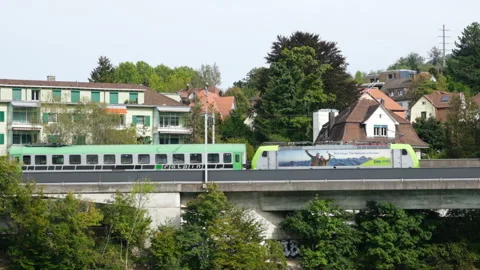 Close up view on arrival of a modern train and bridge, railway track in Olten Stock Footage 216682090