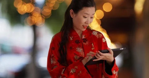 Close view of Asian millennial using handheld tablet pc in urban setting Video stock 87668926