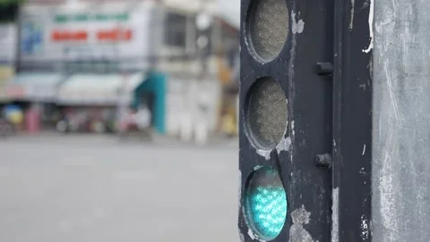 A close view of an Asian traffic light switching signals while motorbikes move Stock Footage 323810218