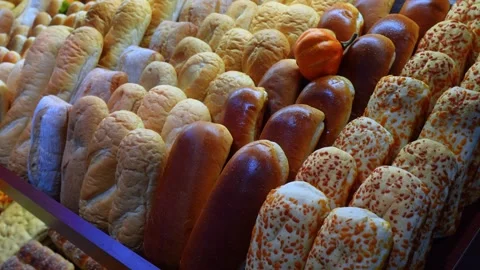 Close up view of assorted freshly baked bread rolls on a bakery shelf. A variety Stockbeeldmateriaal 336339394
