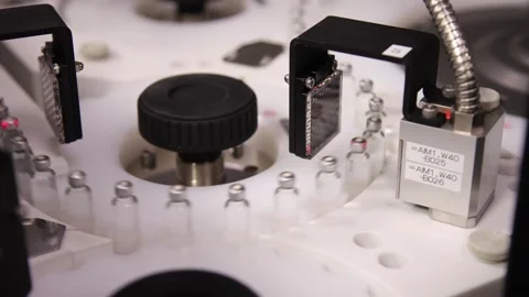 Close-up view of an automated laboratory carousel system processing small glass Stock Footage 333223453