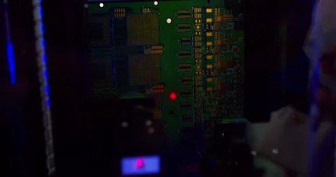 A close up view of automated machinery inserting components onto a circuit board Stock Footage 306778400