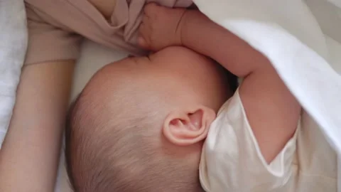 Close up view of Baby fall asleep holding mom on bed Stock Footage 201216329