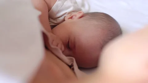 Close up view of Baby fall asleep holding mom on bed Stock Footage 201216404