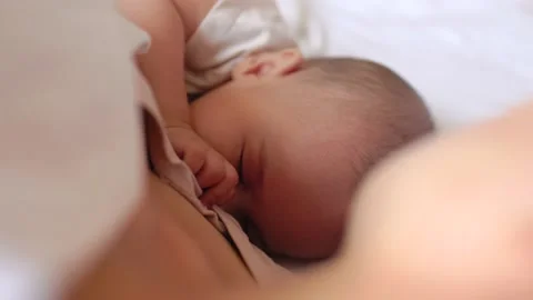 Close up view of Baby fall asleep holding mom on bed Stock Footage 201311652