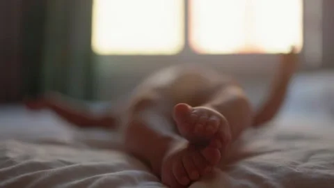 Close up view of baby's legs moving on the bed Stock Footage 201215846