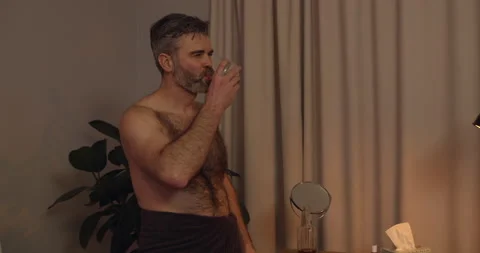 Close up view of bachelor in bath towel singing and moving in rhytm while Stock Footage 135572364