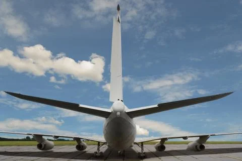 Close-up view from back on big jet airplane against of blue cloudy sky backgr Stock Photos