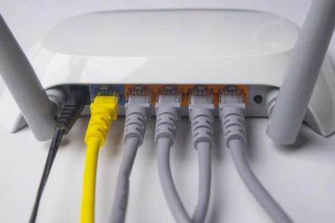 Close-up view of the back panel of a white wireless router, fully connected.. Stock Photos