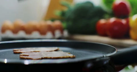 Close-up view of bacon slices in frying pan. Woman prepares bacon for breakfast. Stock Footage 171934657