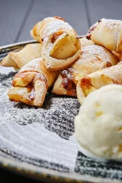 Close up view of baked pear wrapped in pastry with cinnamon served with ice c Foto stock