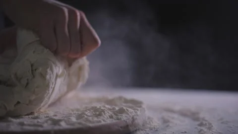 Close up view of baker kneading dough in flour on table. Stock Footage 138567575