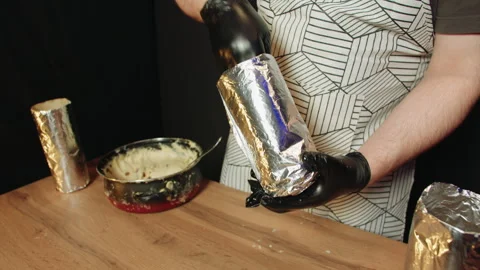 Close view of baker preparing and wrapping molds meticulously Video stock 330536941