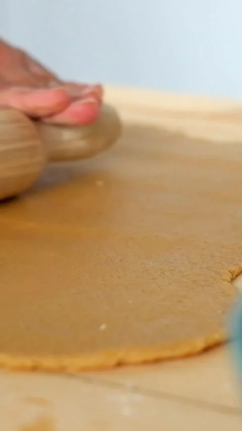 Close up view of a baker using a wooden rolling pin to flatten gingerbread Stock Footage 344785930